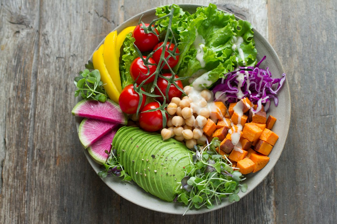 Assiette colorée de salades et légumes frais préparée avec soin, symbole d'une alimentation équilibrée et plaisir